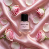 Perfume bottle labeled 'Dopamine Rose' surrounded by pink roses and petals on a pink satin background