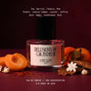 Delusions of Grandeur eau de parfum by L'Epoque surrounded by fresh apricot, saffron threads, dried tobacco leaves, and jasmine blossoms on a deep burgundy background