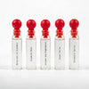 Five L'Epoque Parfums 1mL sample vials with red ball caps, labeled Delusions of Grandeur, Dopamine Rose, Dreams and Nightmares, Inner Child, and Serotonin Spritz