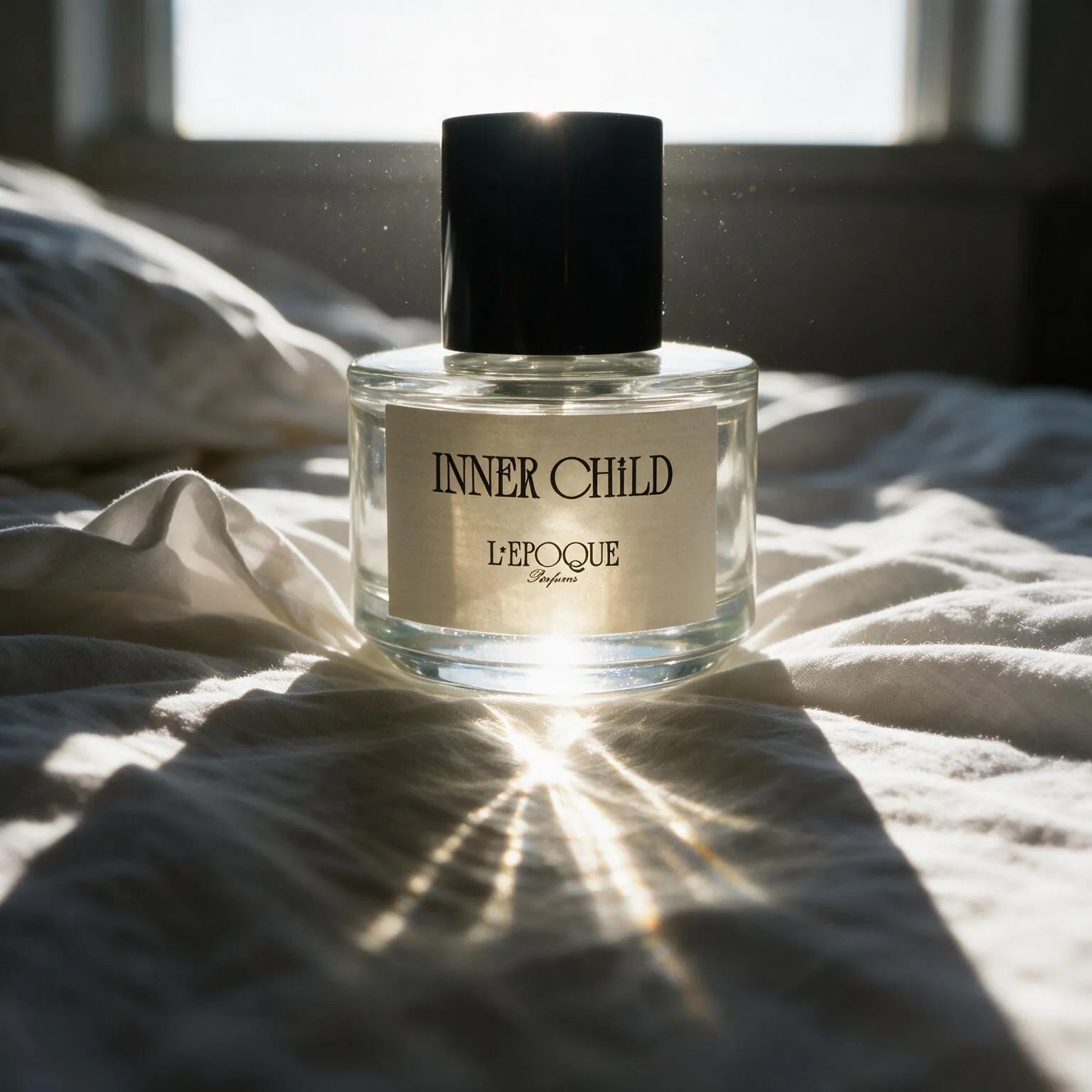 Inner Child eau de parfum 30mL by L'Epoque Parfums, a fresh clean fragrance, in morning sunlight on white linen bedding